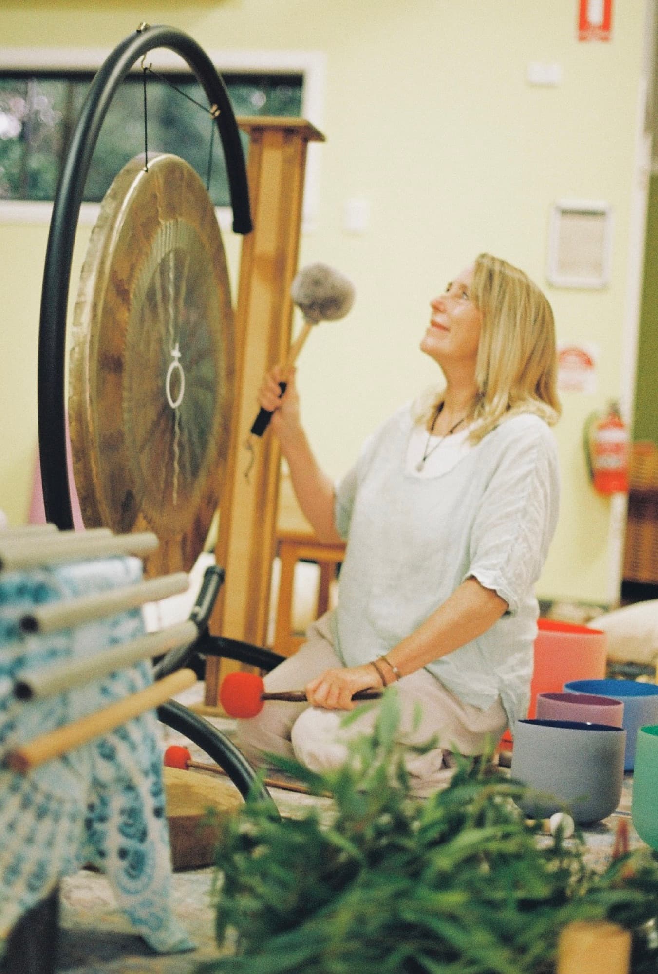 Justine playing the gong at a community gathering