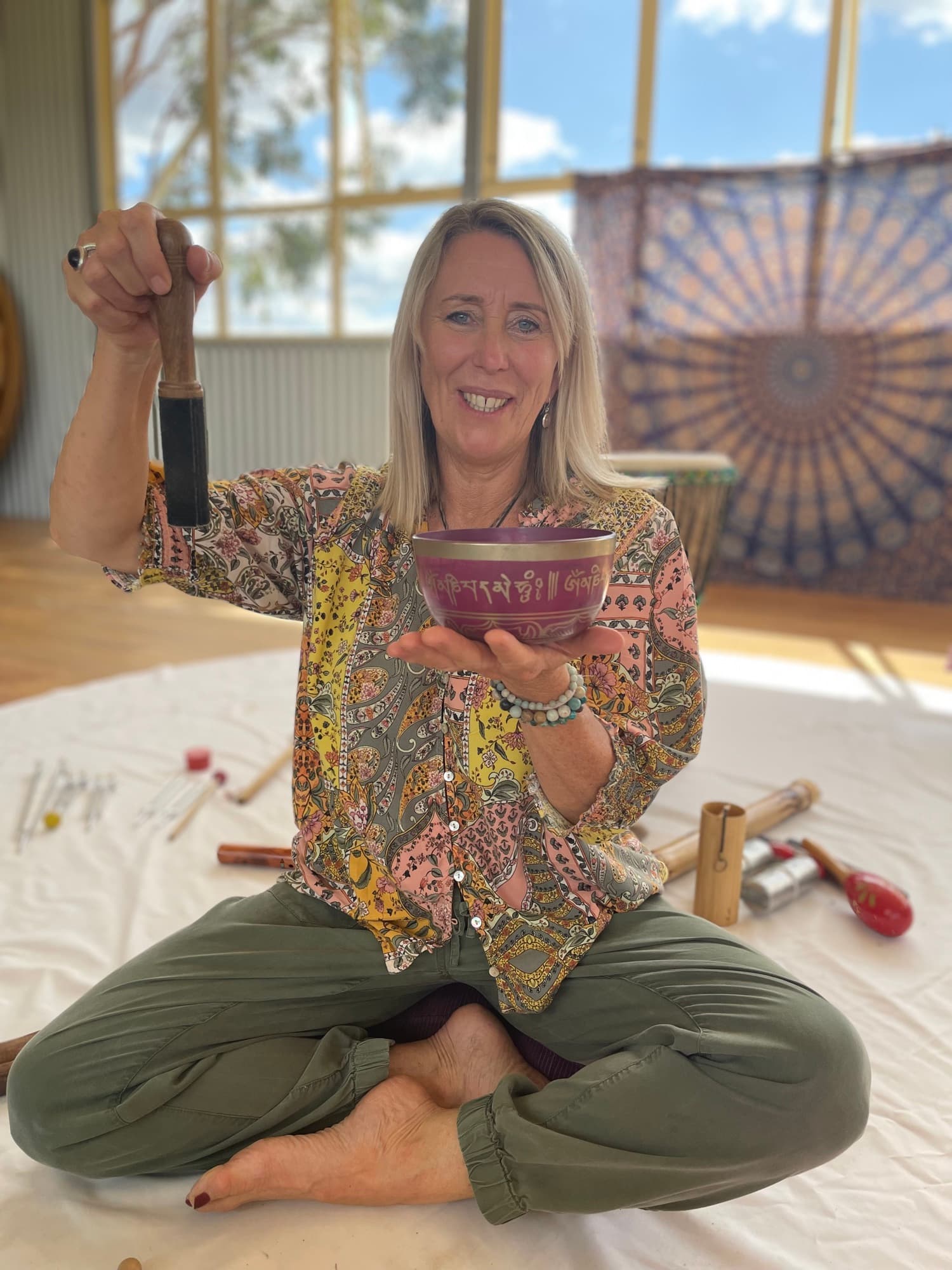 Justine smiling, holding a Tibetan singing bowl